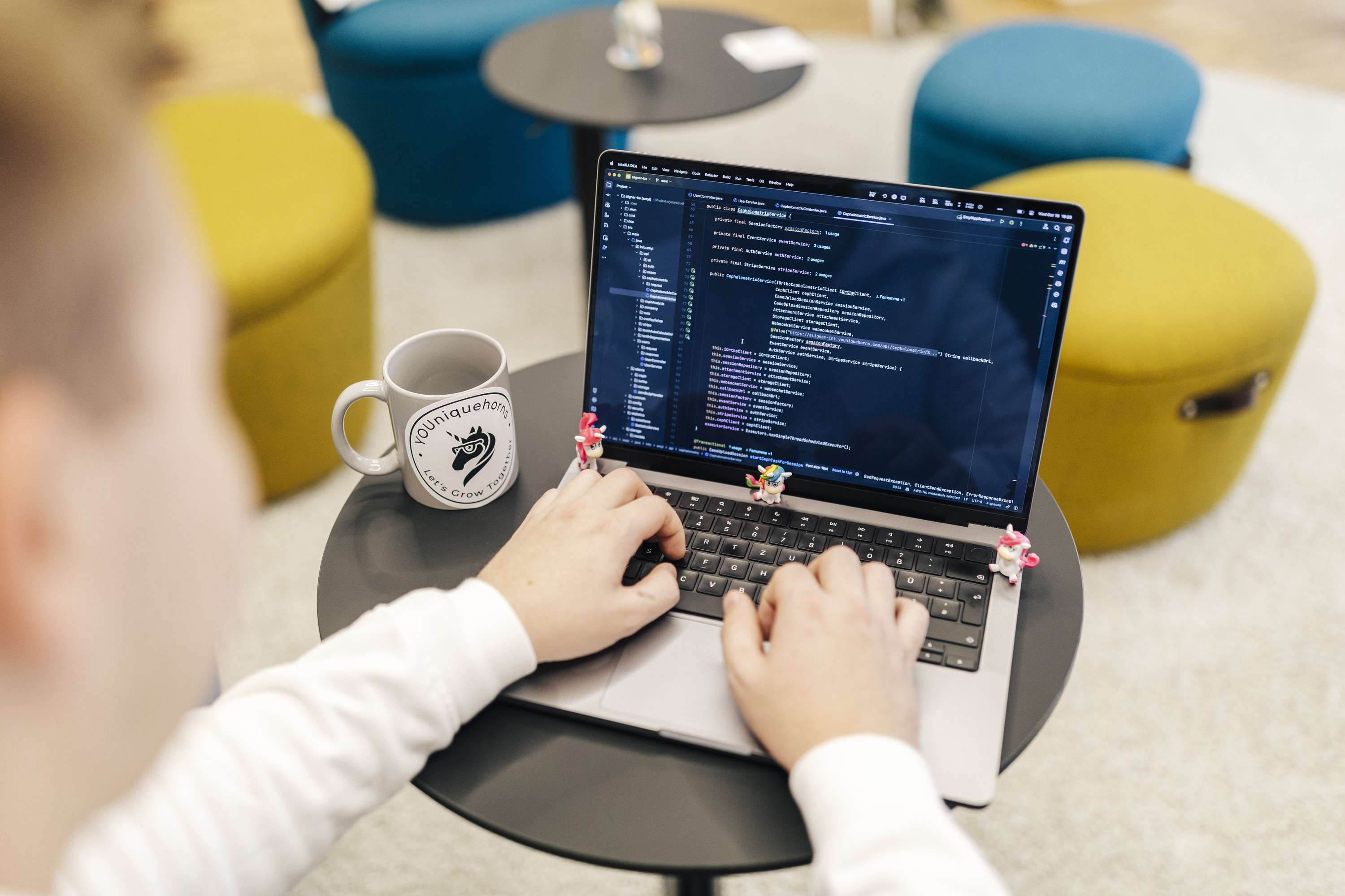 ResQBot Person arbeitet an einem Laptop mit Programmiercode in einem modernen Buero.